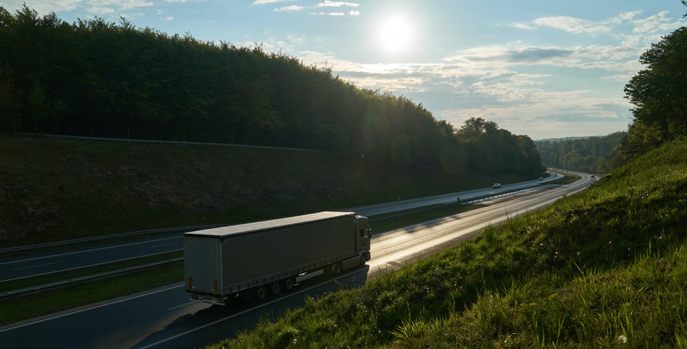 HGV on road surrounded by greenery