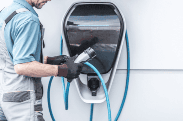 Personal que utiliza el cargador eléctrico del vehículo para la flota