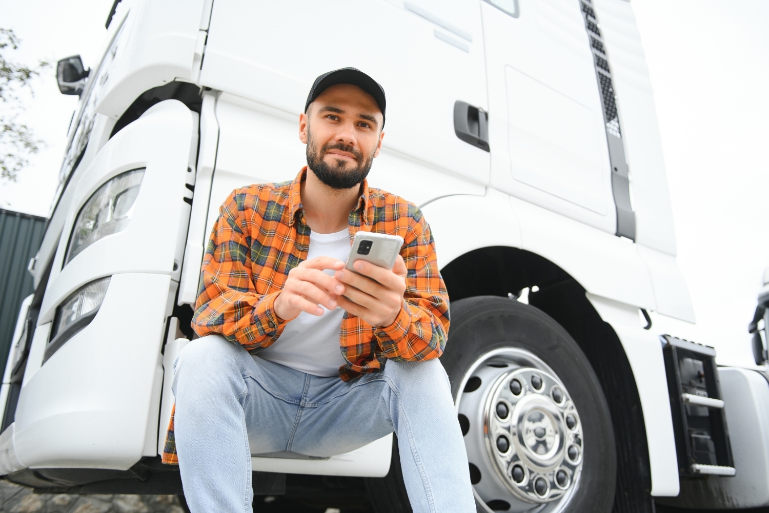 driver sitting on hgv step with mobile