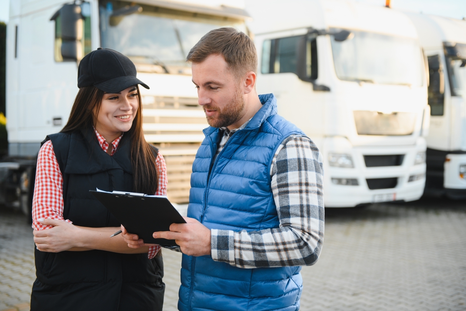 fleet workers with clipboard in front of trucks