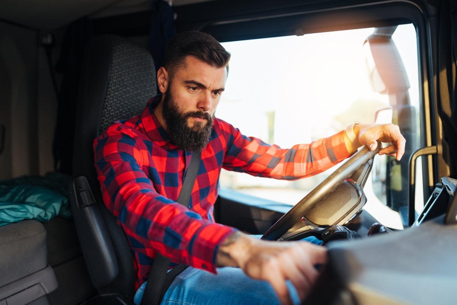 hgv driver at wheel interacting with dashboard