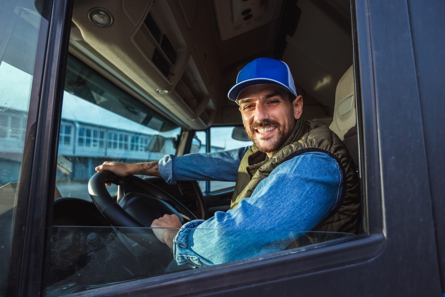 conducteur de poids lourds souriant avec une casquette bleue