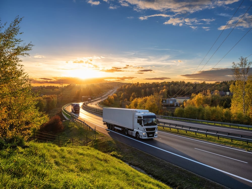 HGVs on road surrounded by greenery