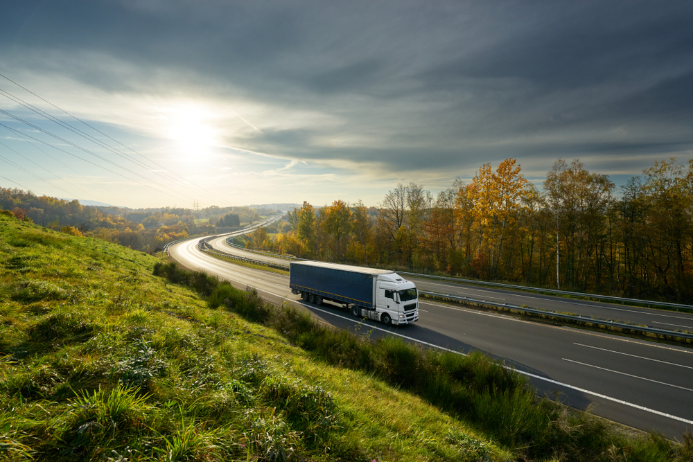 white truck driving on motorway